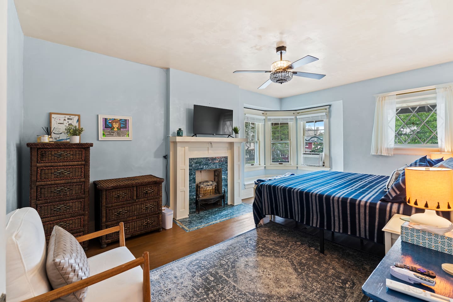 Blue bedroom with fireplace and large windows
